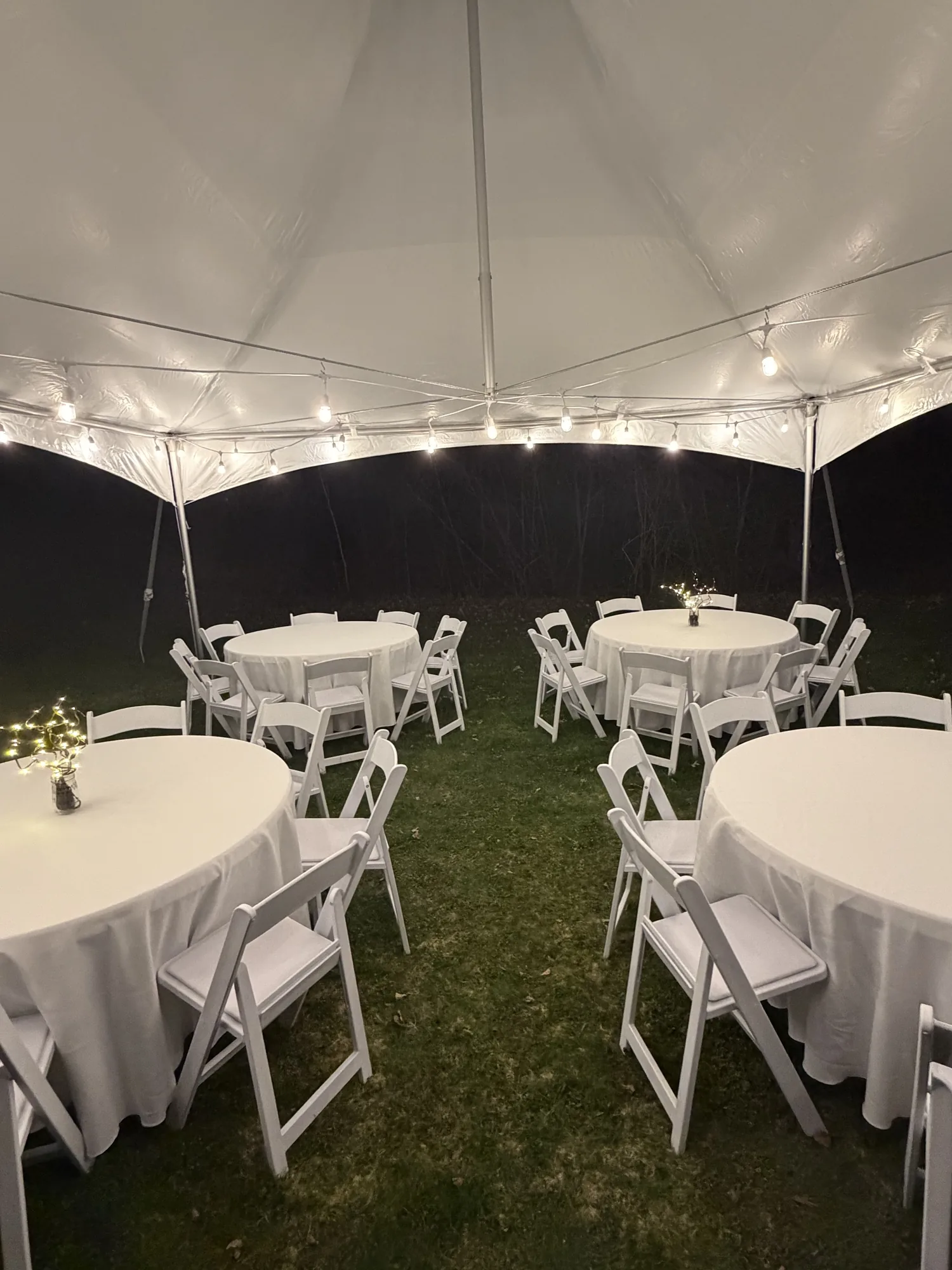 Tables and white chairs arranged beneath an Event Rent ME tent