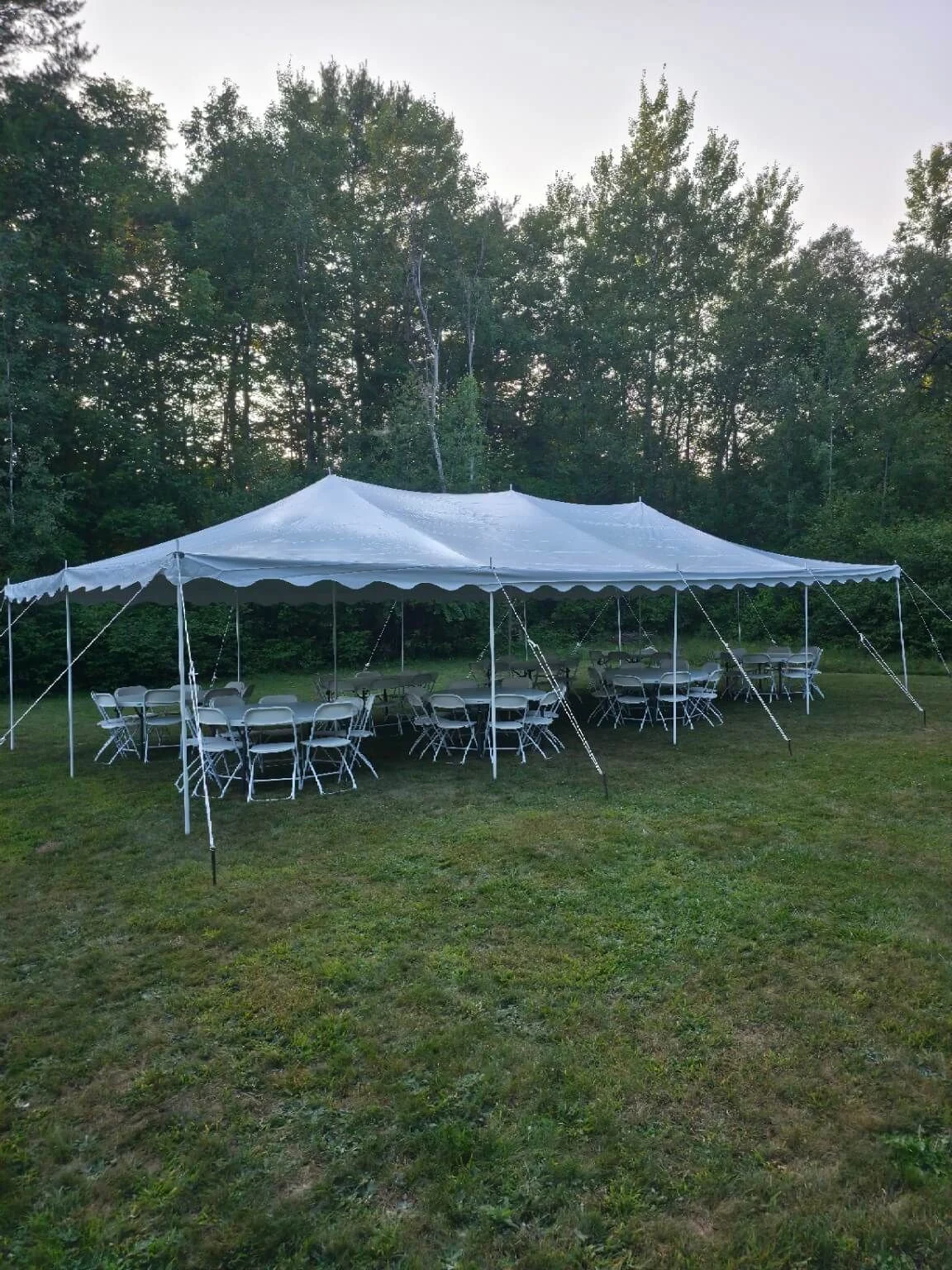 Outdoor event tables and chairs under a tent