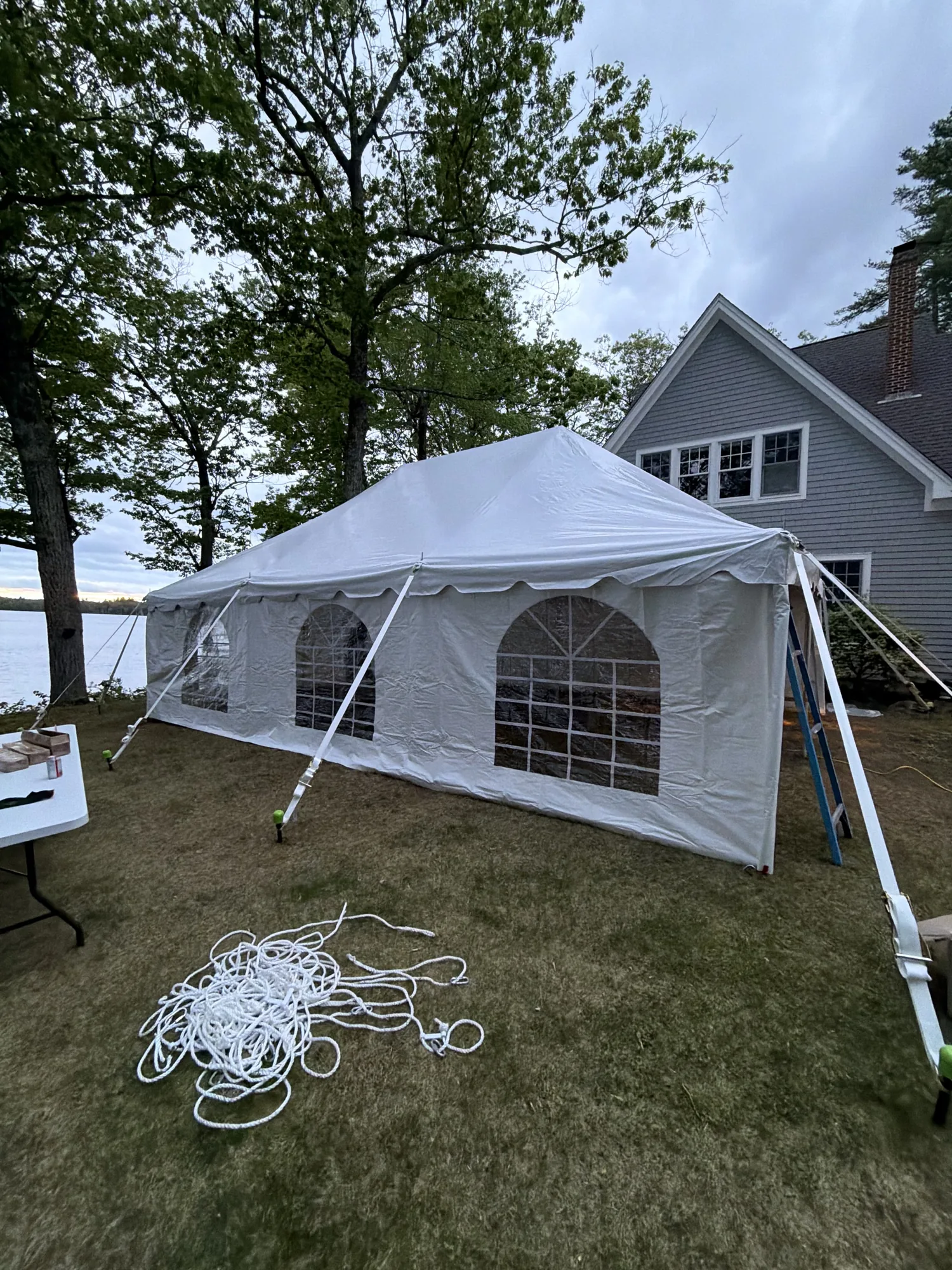 Quiet lakeside tent setup with weather sidewalls
