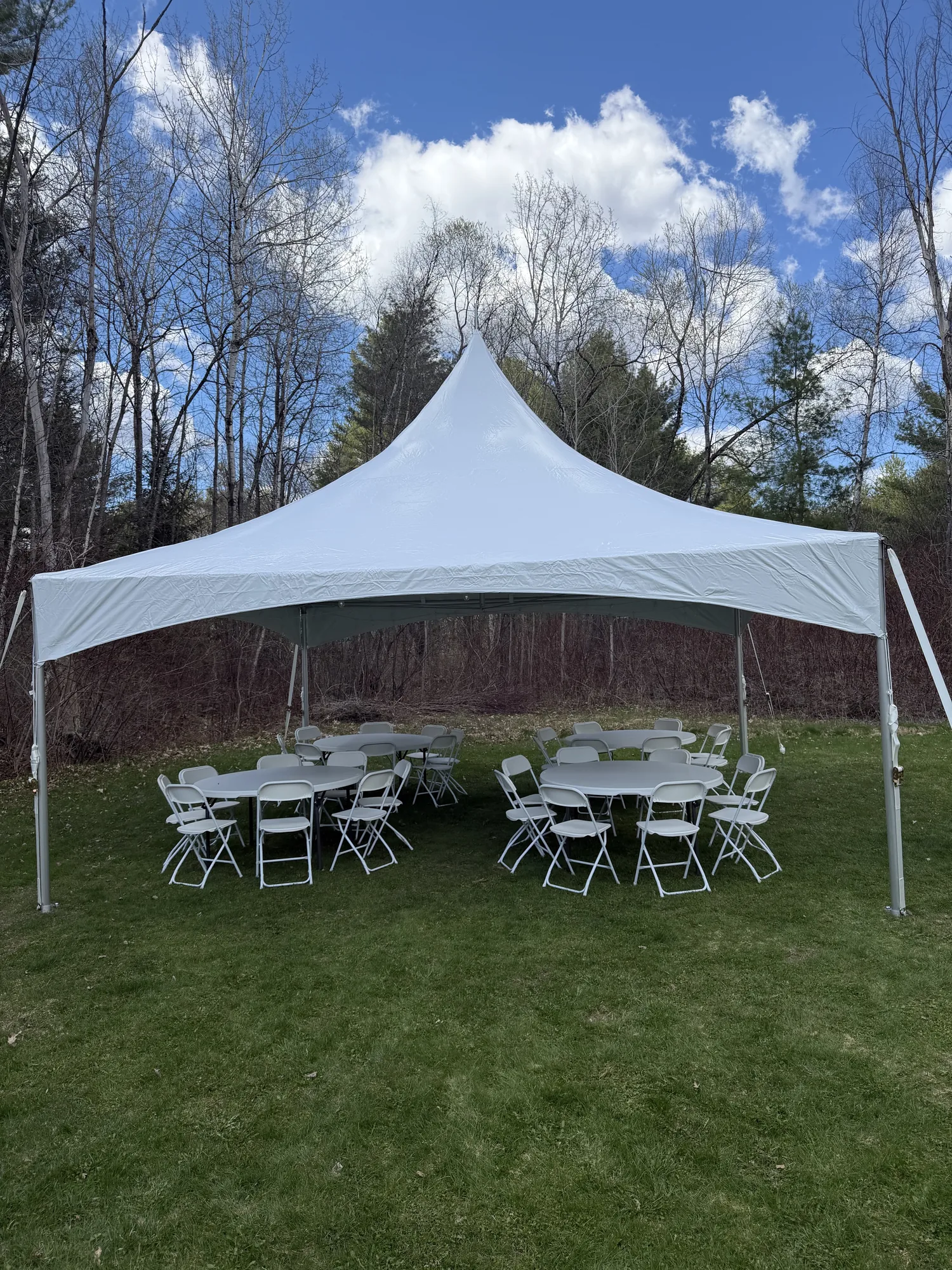 Graduation party tent with tables and chairs on a sunny lawn